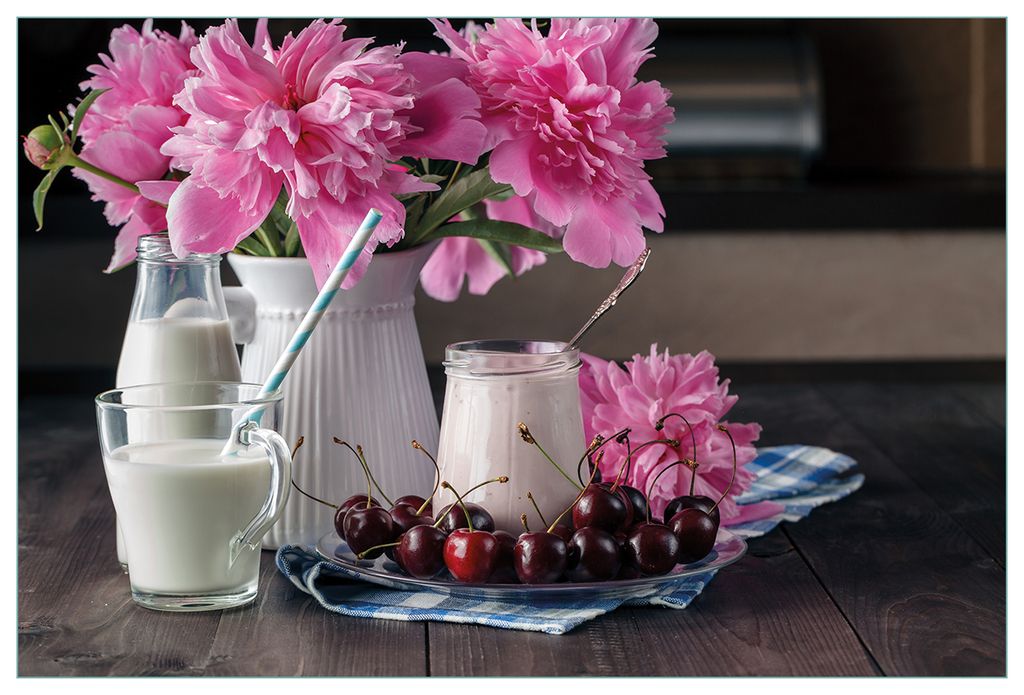 Wallario Küchenrückwand aus Glas, Größe: 90 x 60 cm, Motiv: Milch mit Kirschen zum Frühstück mit rosa Blumenarrangement | Spritzschutz | abwi...