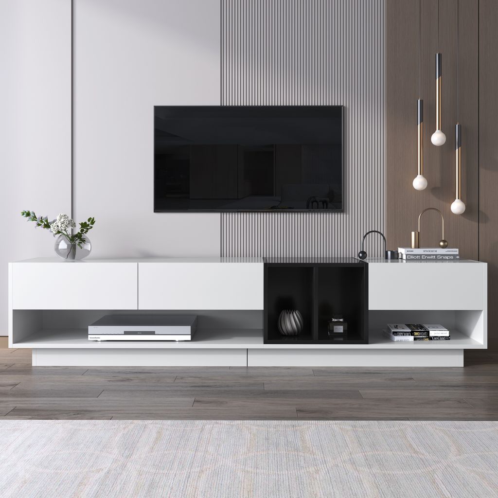 A modern living room setup with a TV mounted on a wall above a white and black media console.