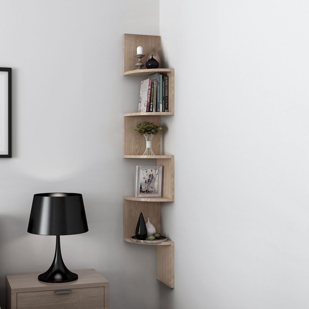 A corner shelf unit with decorative items and books, next to a nightstand with a lamp.