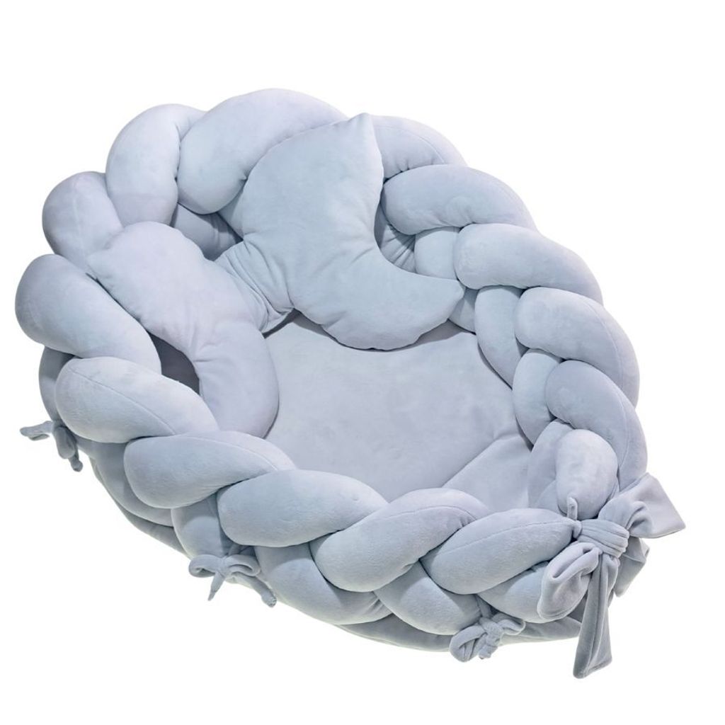 A light blue braided baby nest on a white background.