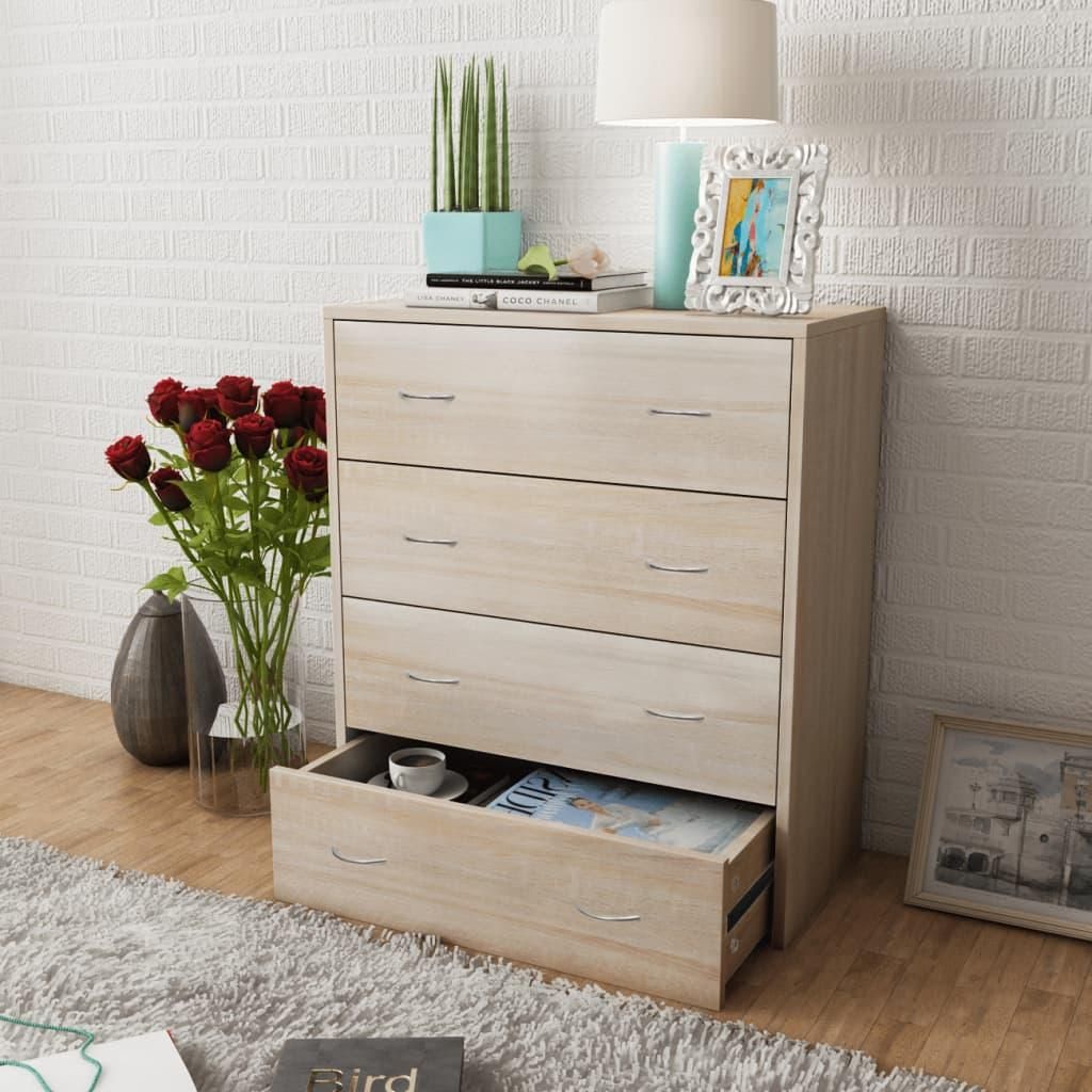 A dresser with open drawers, decorated with flowers and a lamp, in a room setting.