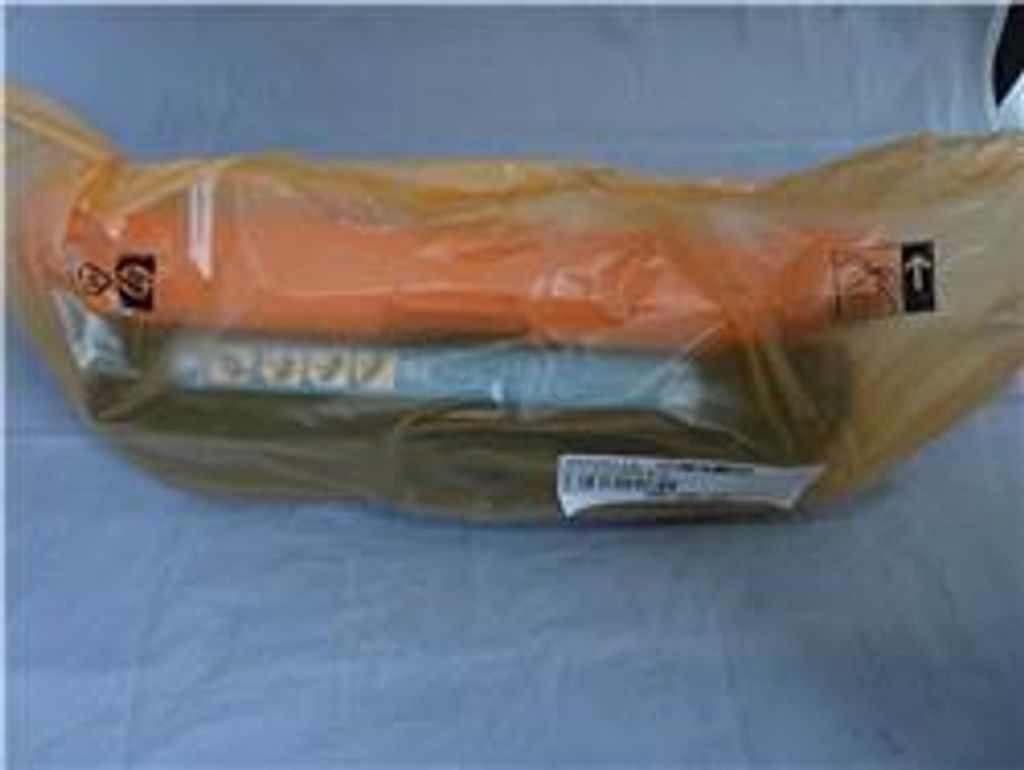 A product wrapped in plastic packaging, lying on a light gray surface.