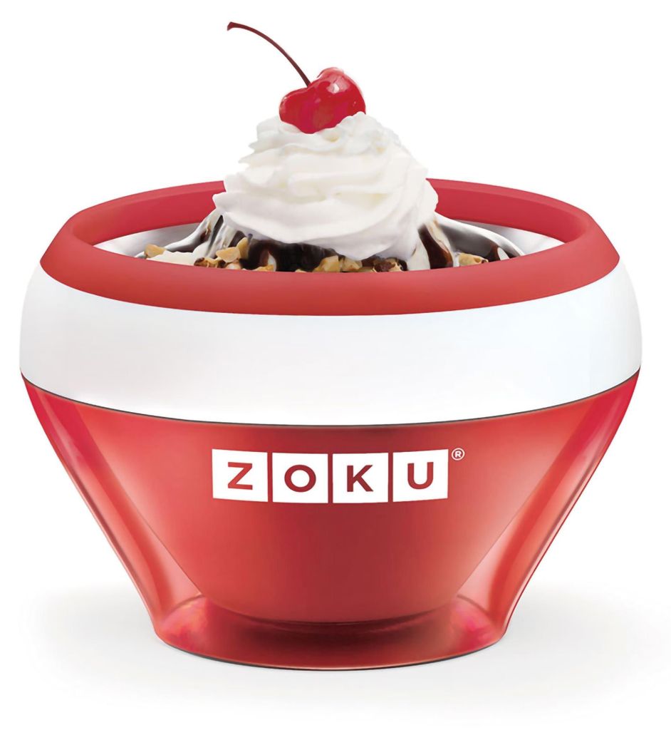 A Zoku ice cream maker in red and white, filled with ice cream, whipped cream, chocolate sauce, nuts, and a cherry on top.