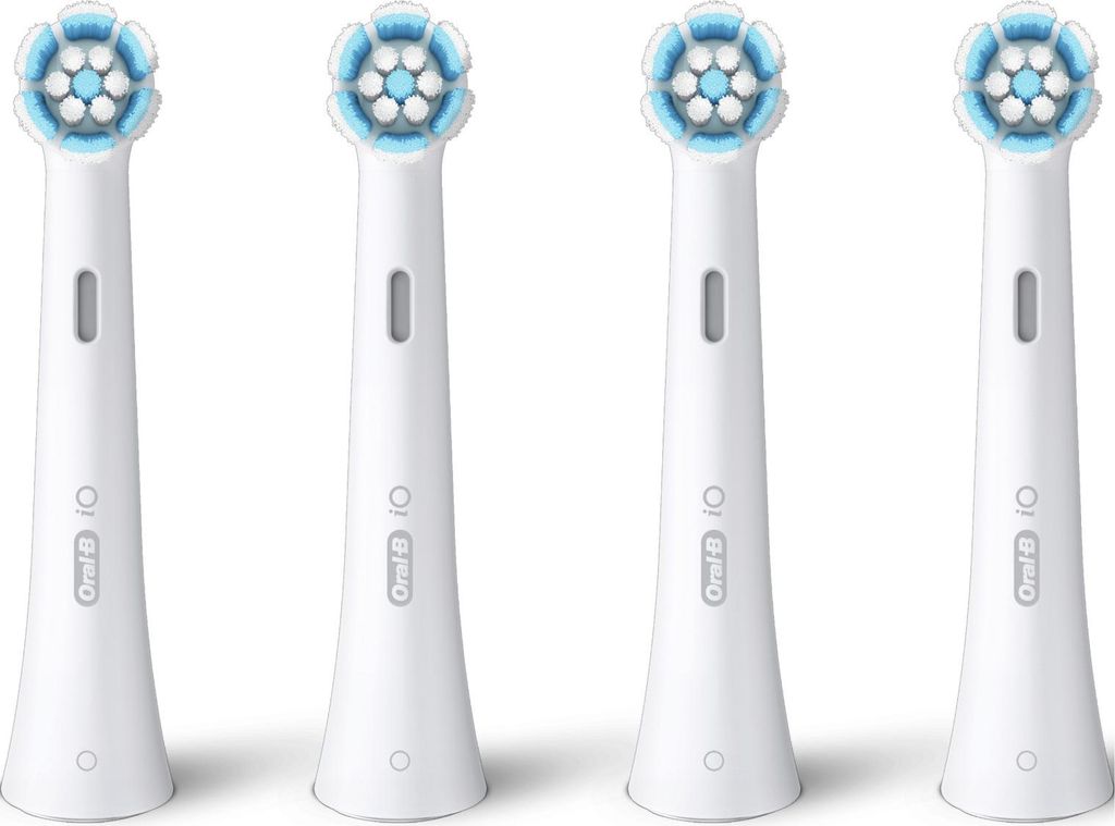 Four white Oral-B iO toothbrush heads are arranged in a row against a white background.