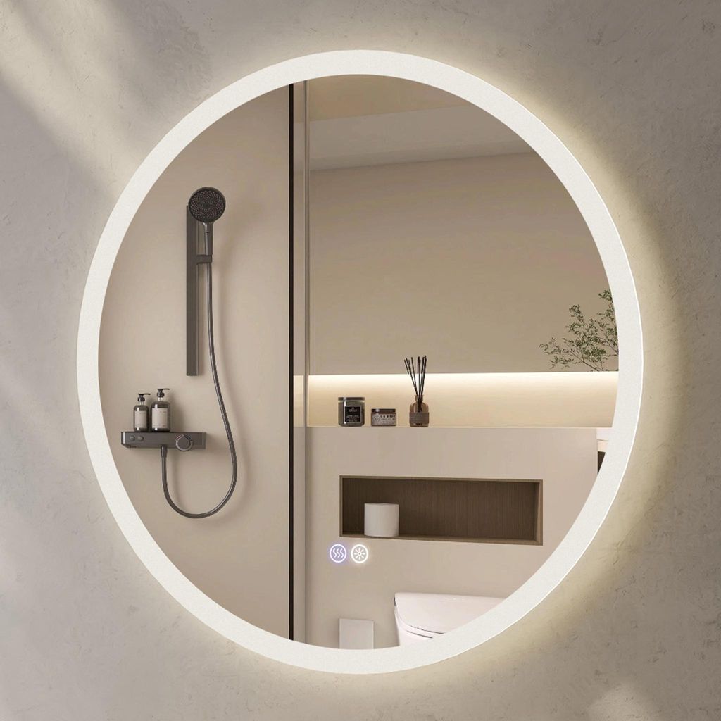 A round illuminated mirror in a modern bathroom setting, reflecting a shower and toiletries.