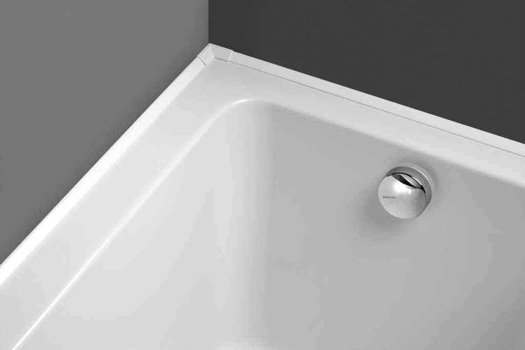 Close-up view of a white bathtub corner with a chrome drain.