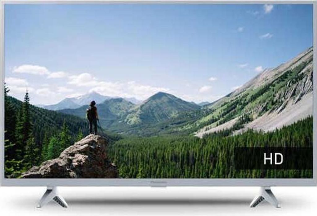 A television displaying a scenic mountain landscape with a person standing on a rock.