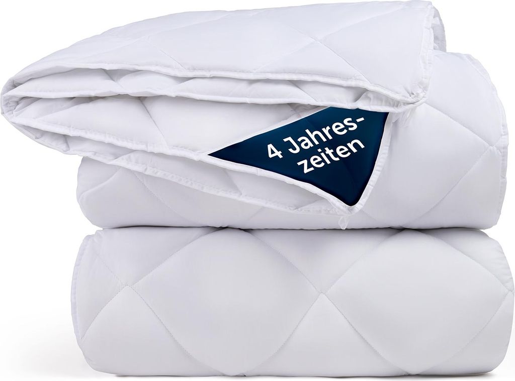 A stack of white quilted duvets.
