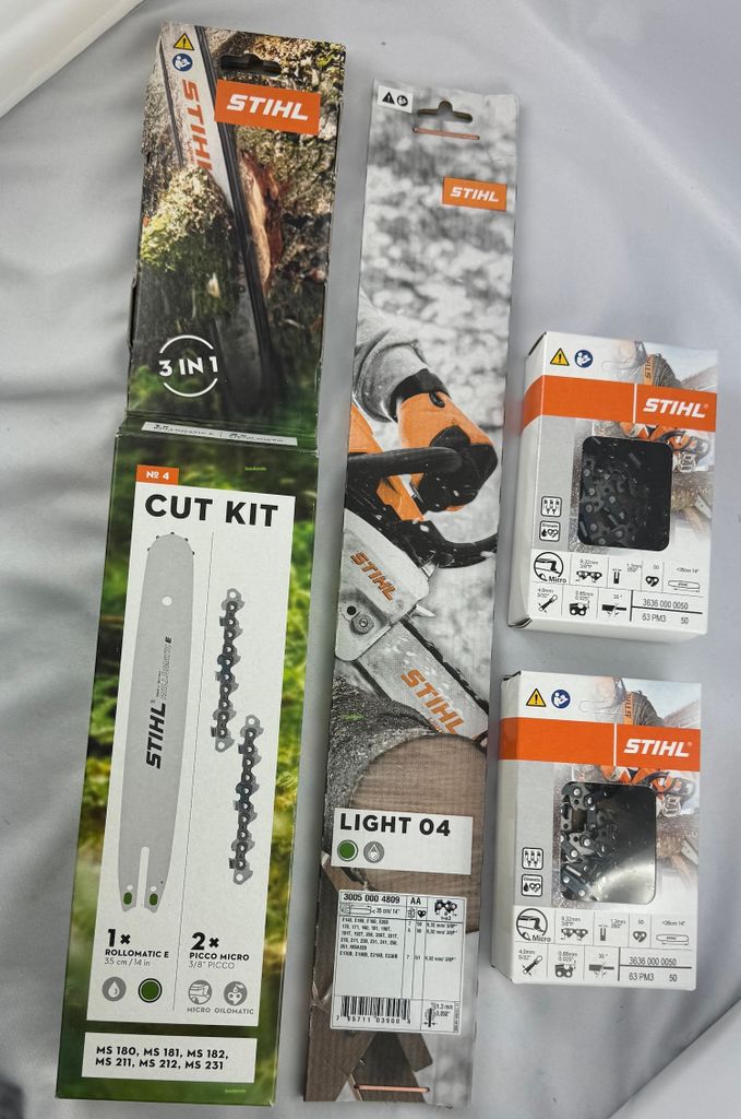 Several Stihl product packages are laid out on a white and light gray surface.