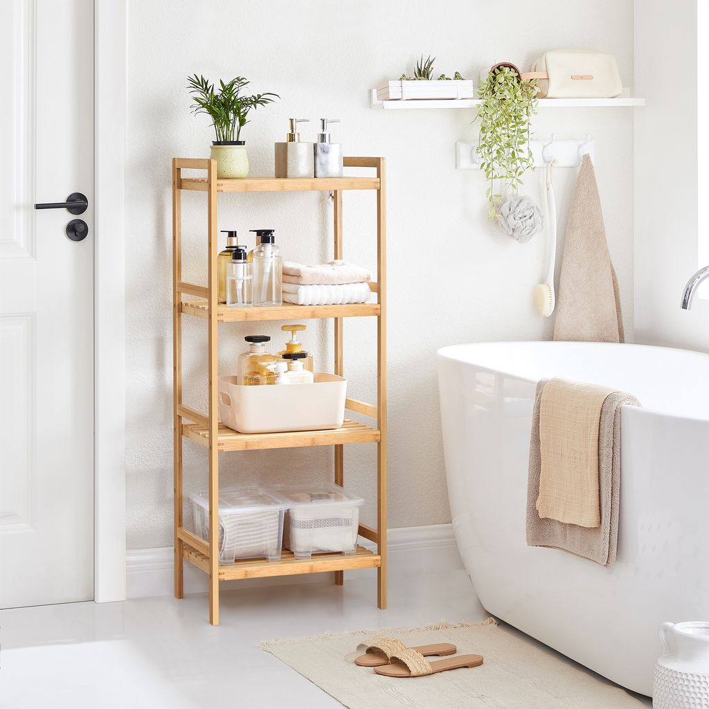 A bathroom scene with a wooden shelf unit filled with toiletries and towels next to a bathtub.