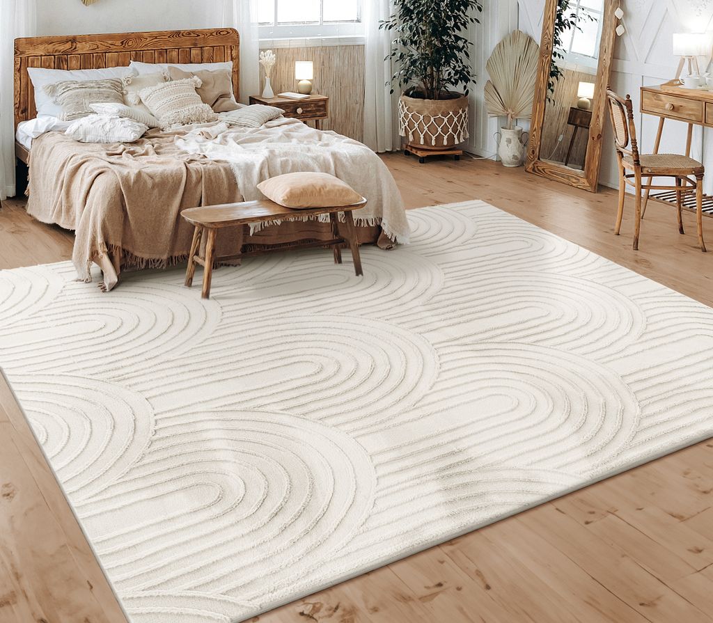A bedroom scene with a bed, rug, and furniture.