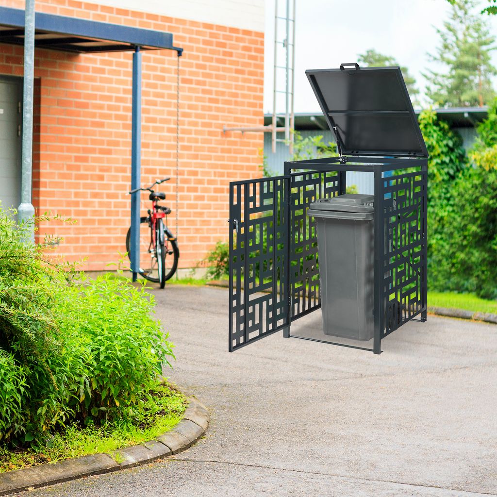 A trash can enclosure is shown next to a brick building with a bicycle parked nearby.