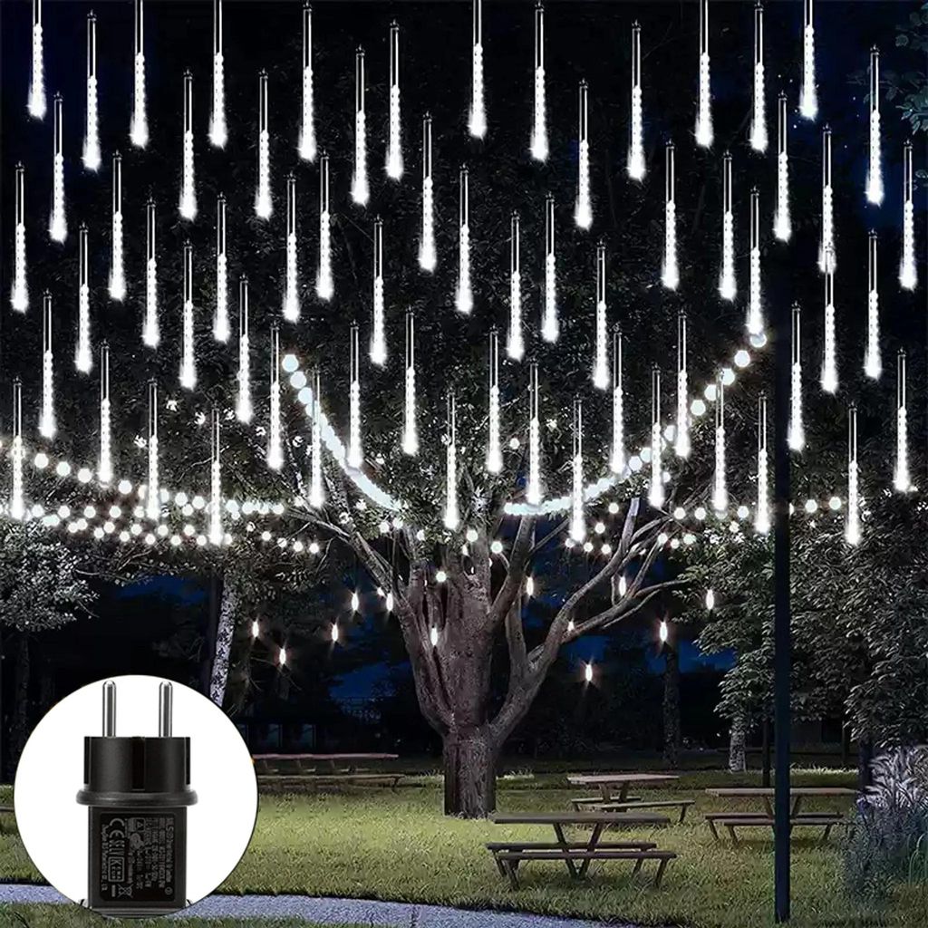 Outdoor scene at night with decorative lights strung on a tree and a power adapter shown in a circle.