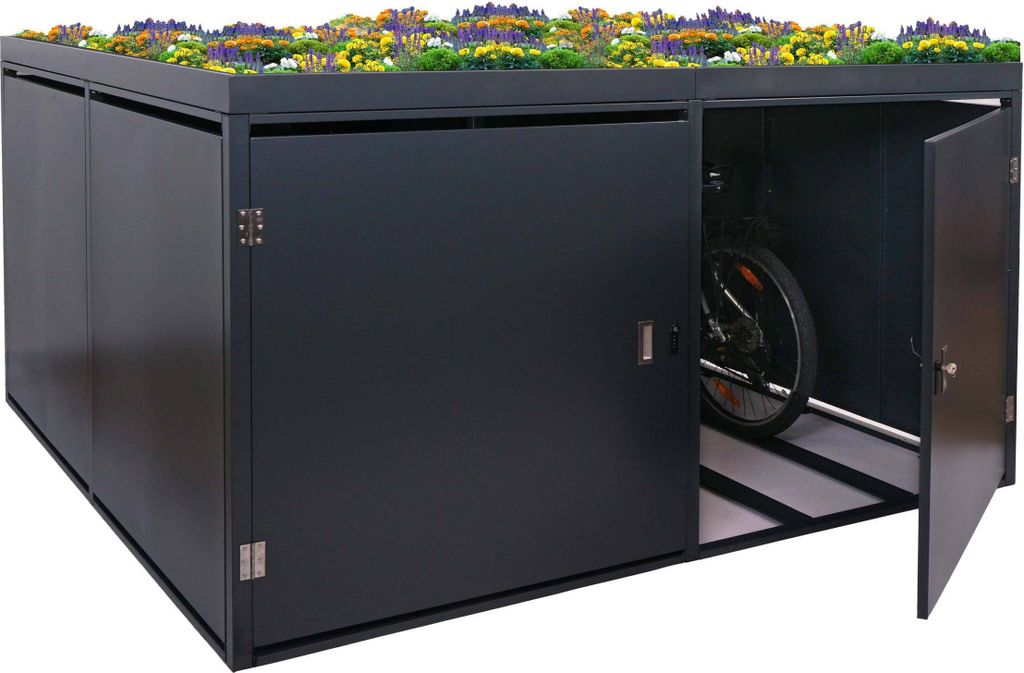 A dark grey bicycle garage with a green roof covered in flowers, one door is open revealing a bicycle inside.