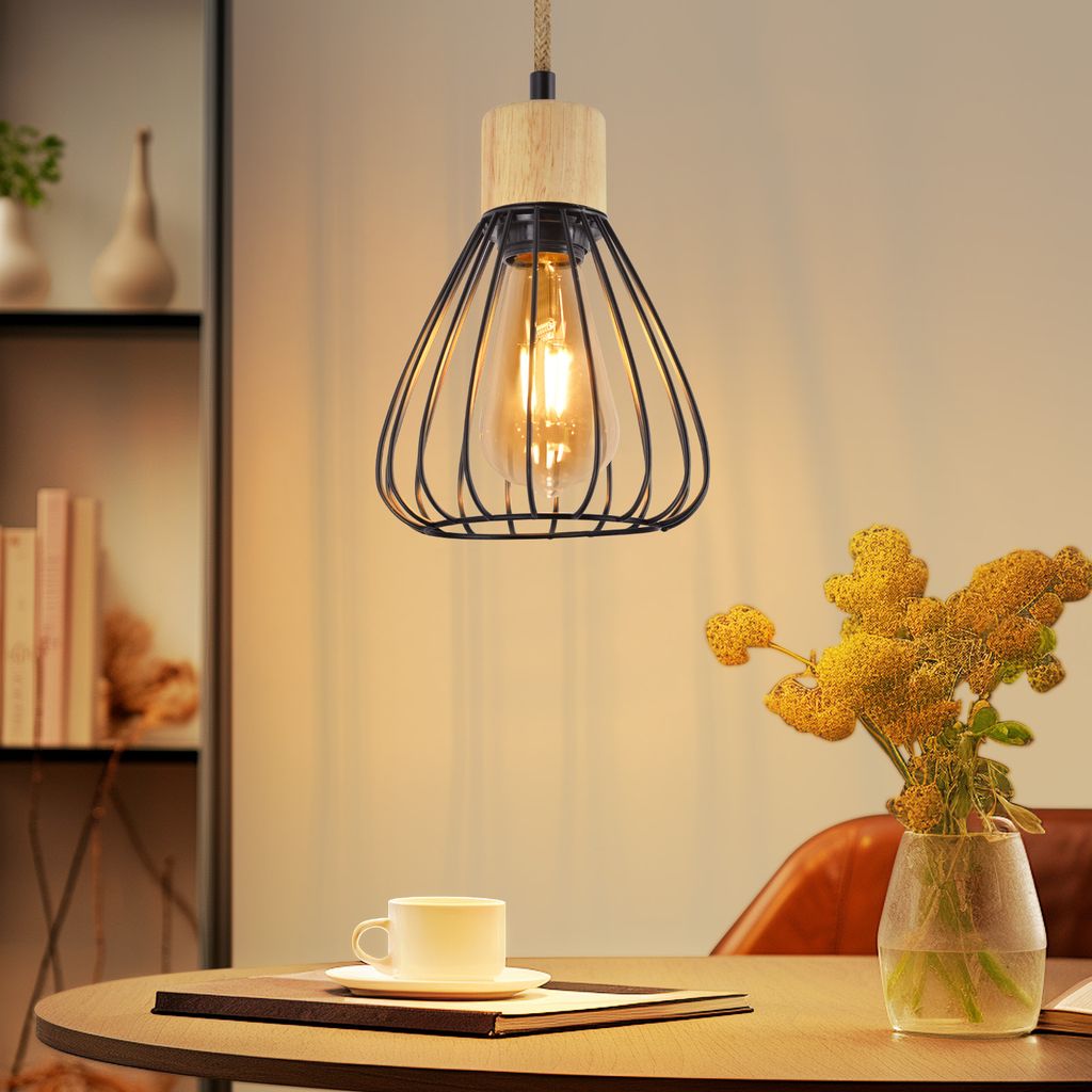 A pendant light hangs above a table set with a cup of coffee and a vase of flowers.