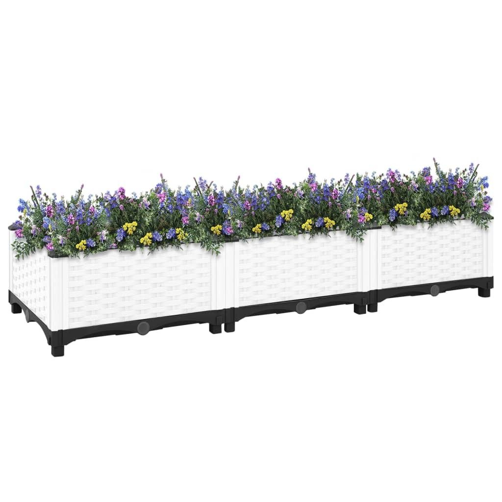 A long, white, modular planter box filled with purple and yellow flowers, set against a white background.