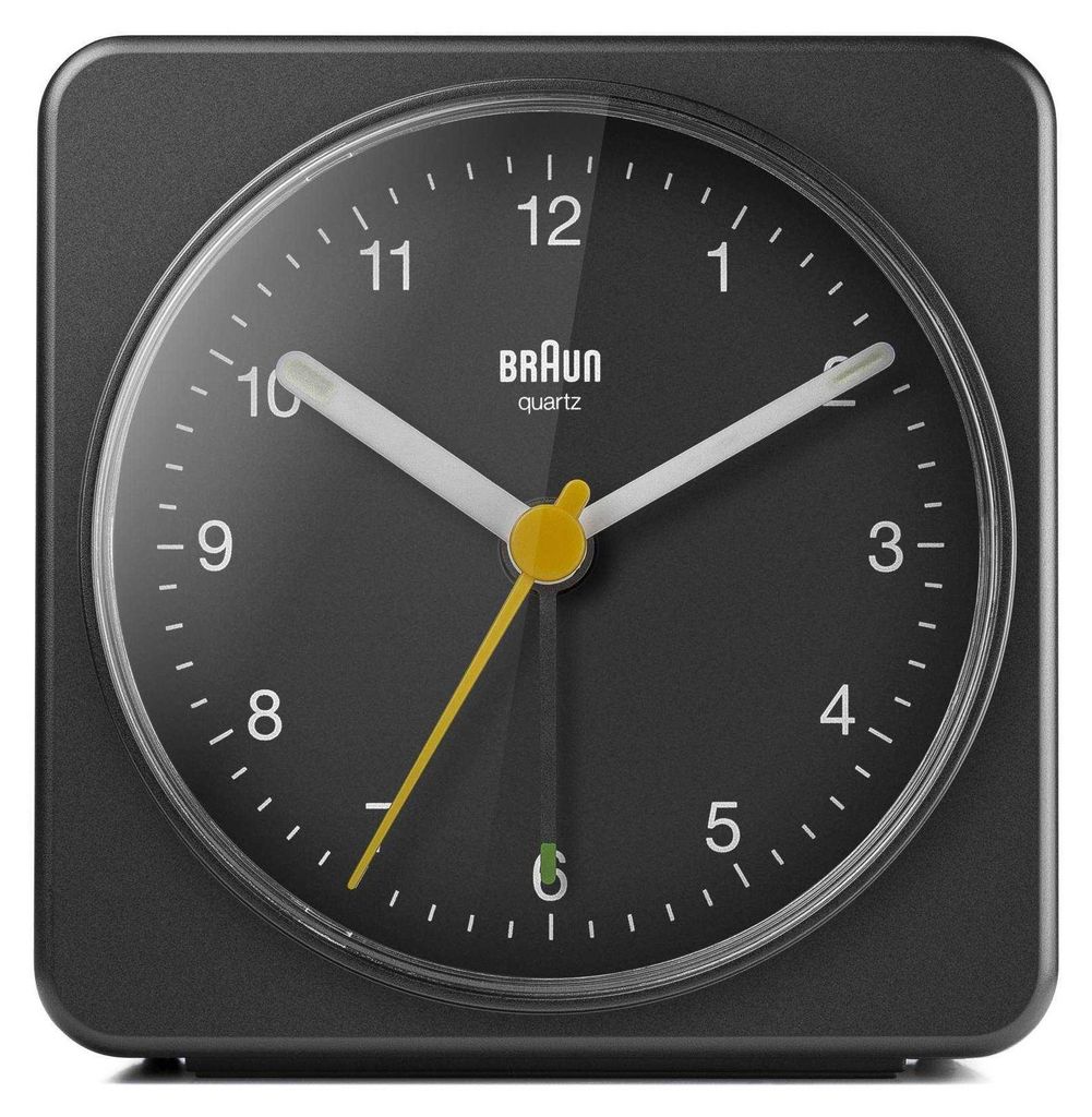 A close-up, front-facing view of a black Braun analog alarm clock.