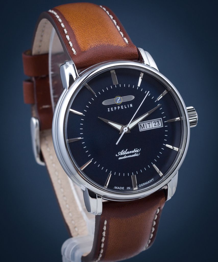 A close-up shot of a men's wristwatch with a dark blue dial and a brown leather strap.