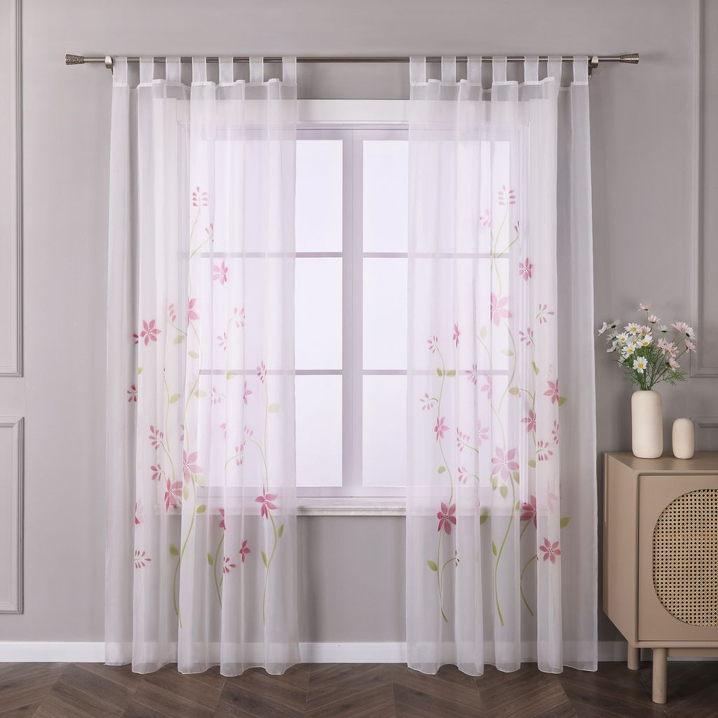 A window with sheer curtains featuring a floral pattern.