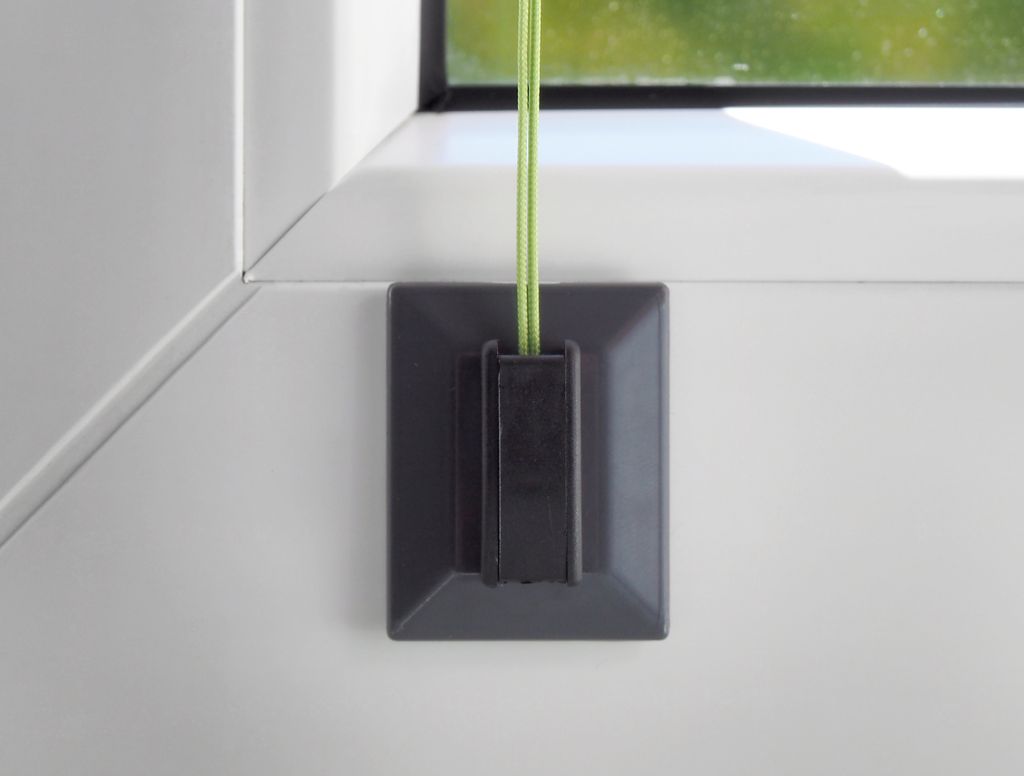 A close-up shot of a window blind accessory attached to a window frame.