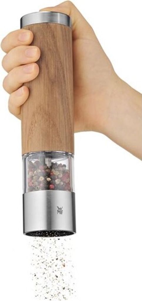 A hand holding a pepper grinder, with pepper being ground.