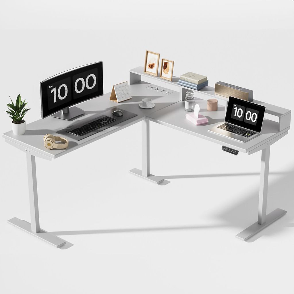 A white L-shaped standing desk with computer monitors, a laptop, and office accessories.