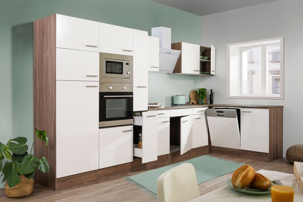 A modern kitchen with white cabinets and wood accents, featuring integrated appliances and a window.