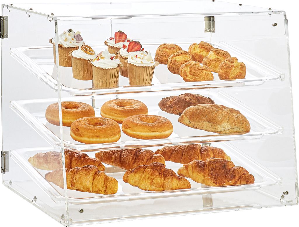 A three-tiered clear acrylic display case filled with various baked goods, including cupcakes, donuts, croissants, and other pastries.