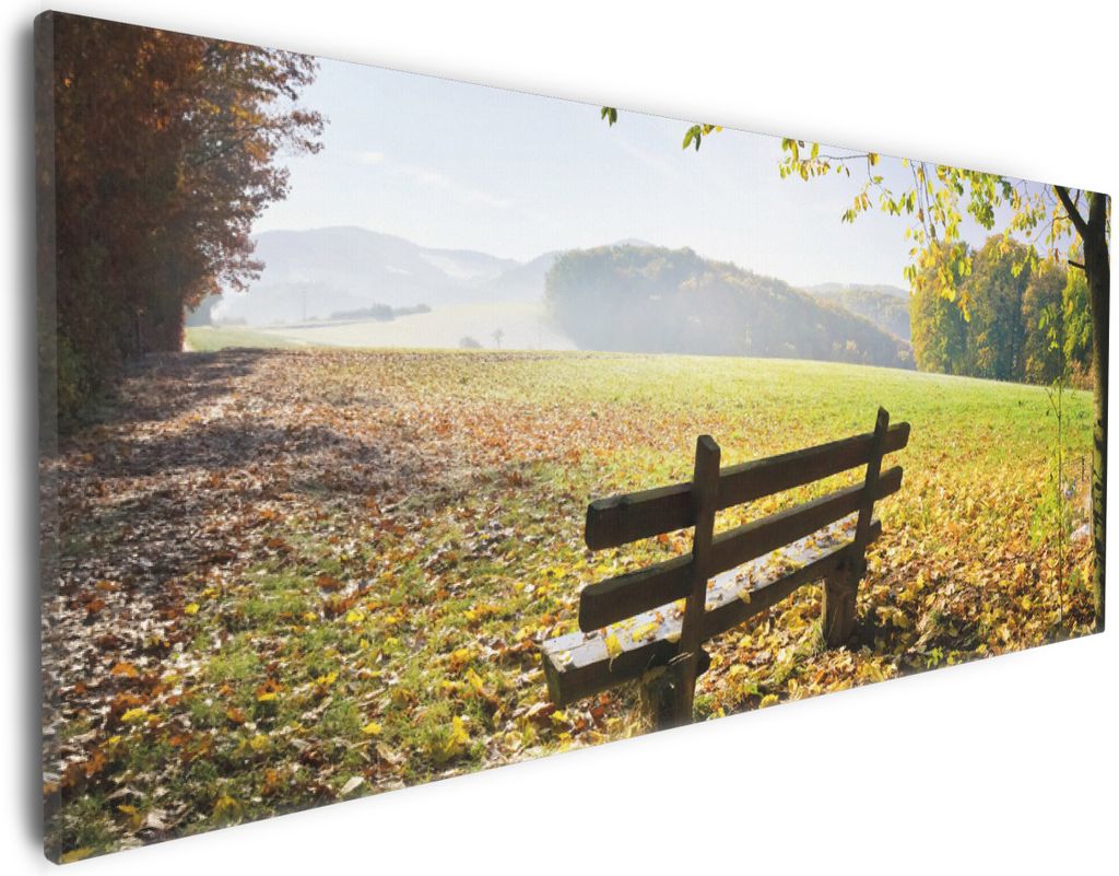 Wallario Premium Leinwandbild Idyllische Holzbank in den Bergen in Größe 30 x 75 cm