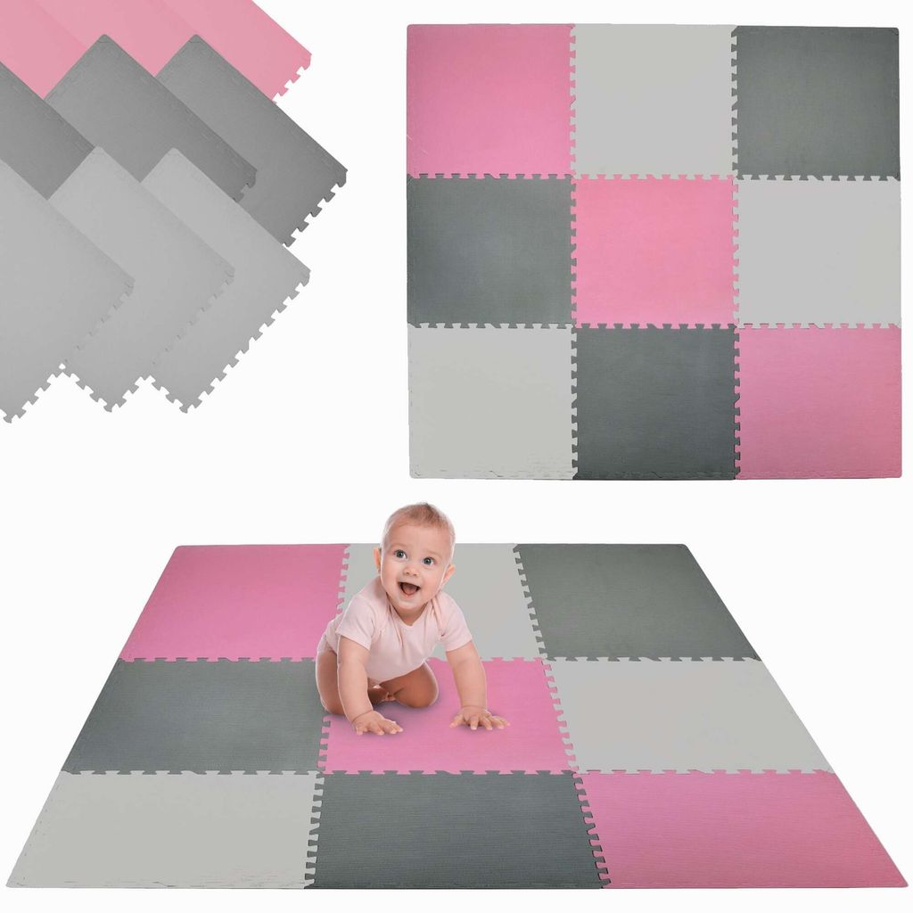 A baby crawling on a play mat made of interlocking foam tiles.