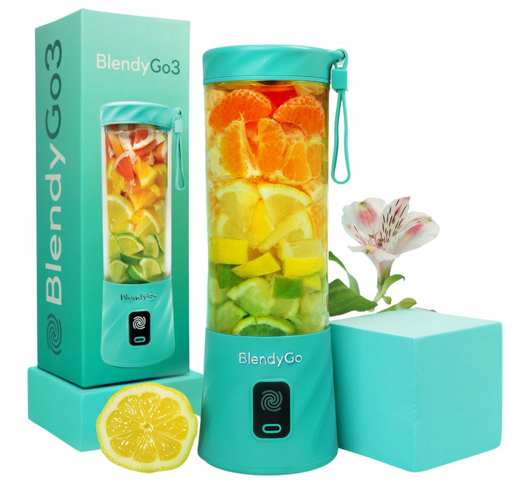 A teal BlendyGo 3 portable blender filled with citrus fruits and oranges, displayed next to its packaging and a sliced lemon. A flower is also visible.
