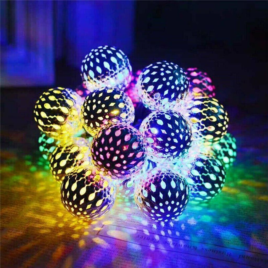 A string of decorative globe-shaped lights with intricate patterns, casting colorful light patterns on a surface.