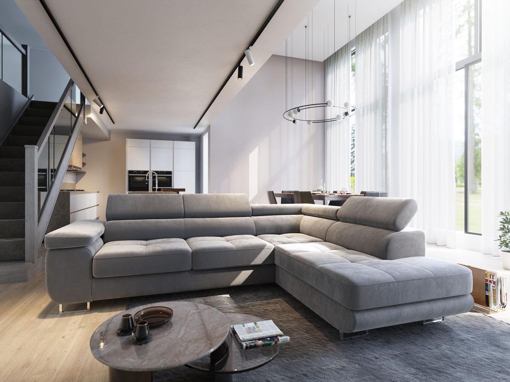 A modern living room with a large sectional sofa, dining area, and staircase.