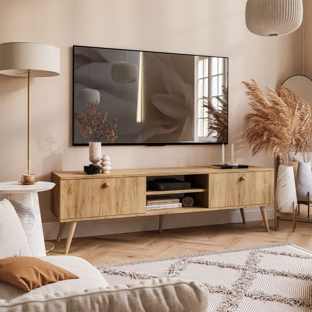 Living room with a TV, TV stand, floor lamp, and decorative items.