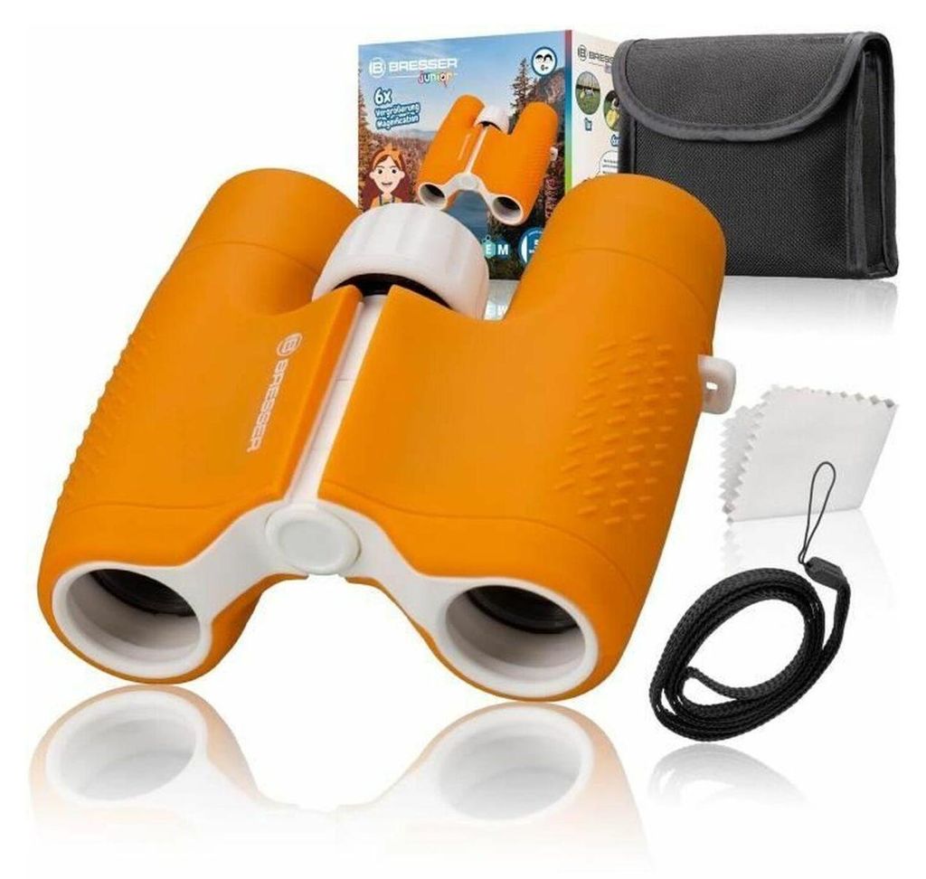 A product shot of children's binoculars and accessories, with packaging in the background.