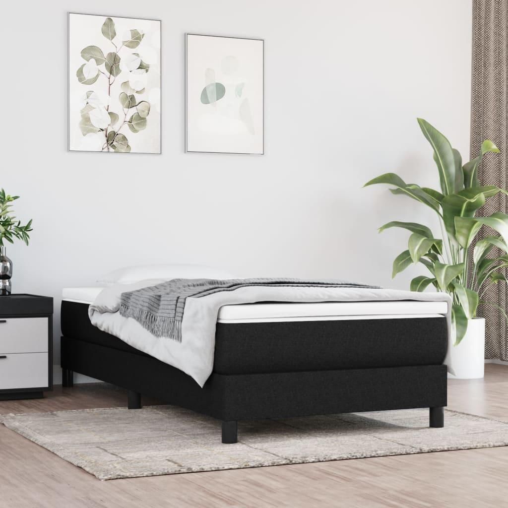 A bedroom scene with a bed and artwork on the wall.