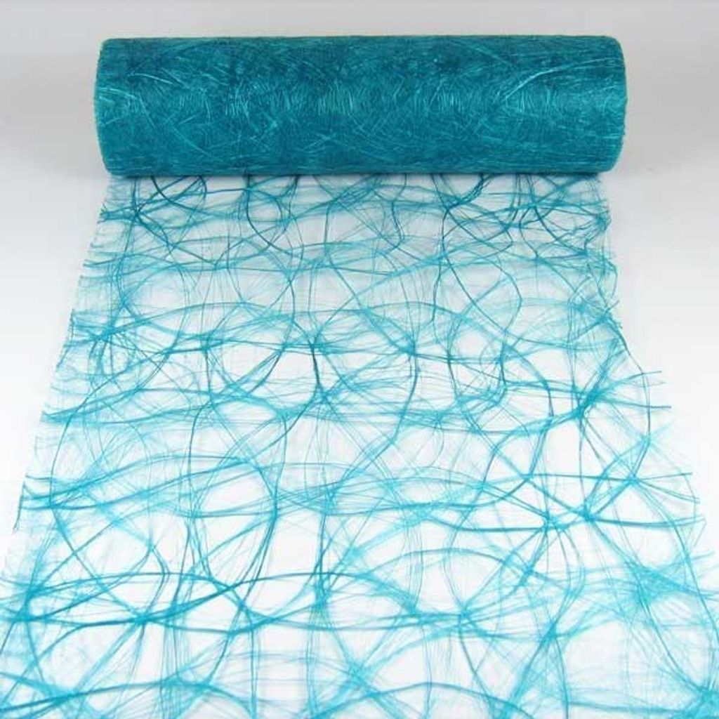 A roll of decorative fabric with a circular pattern, unrolled on a white surface.
