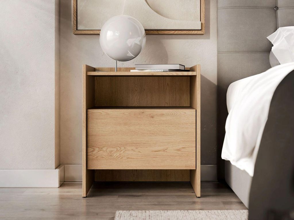A wooden nightstand next to a bed in a bedroom.