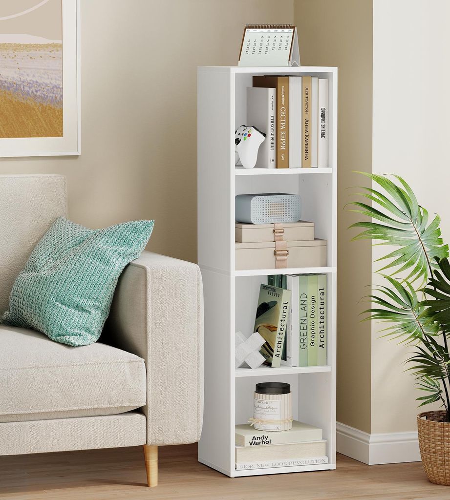 A white bookshelf filled with books and decorative items in a living room setting, next to a sofa.