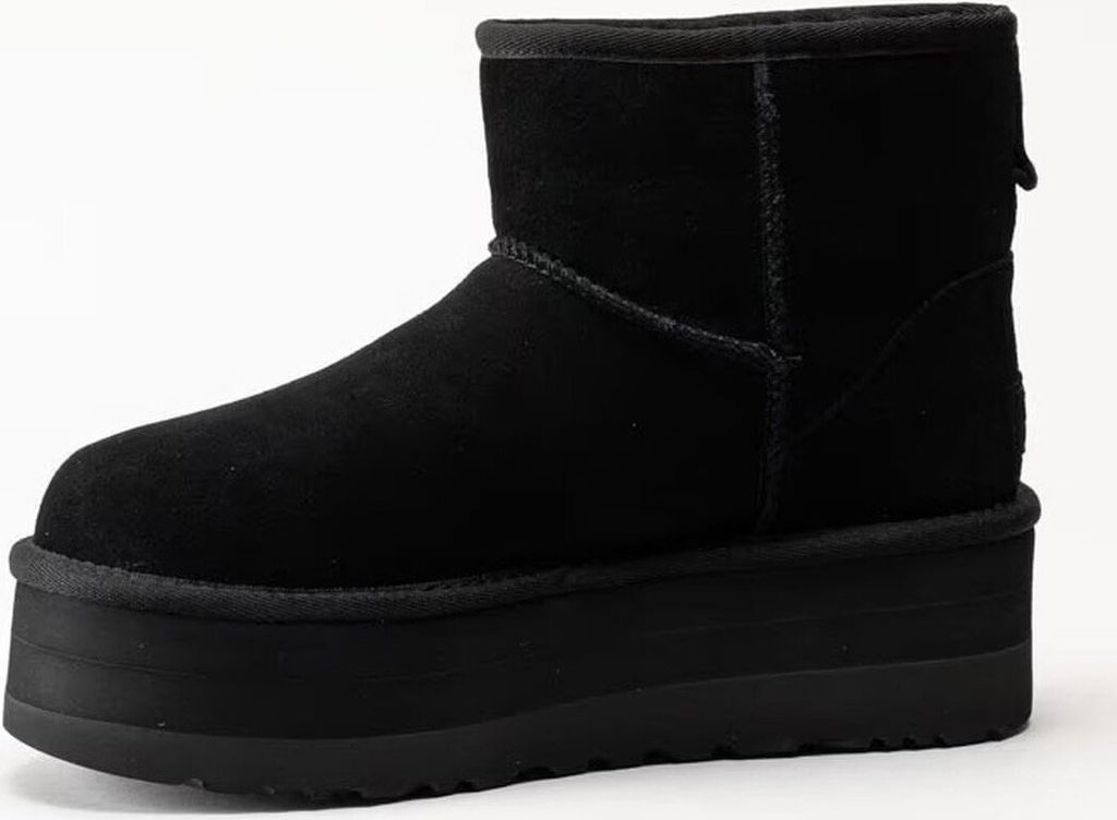 A black UGG boot with a platform sole is shown against a white background.