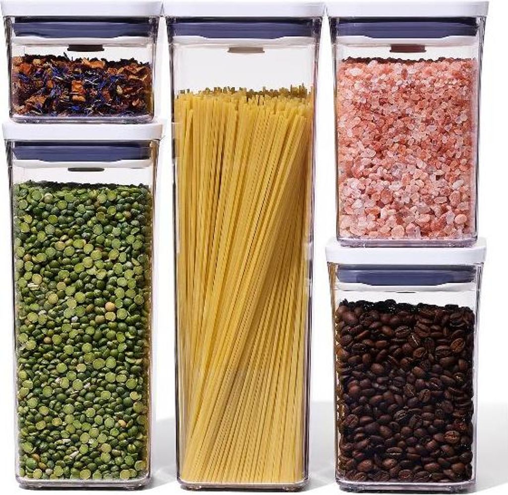 A set of five clear plastic food storage containers with blue lids, filled with various food items.