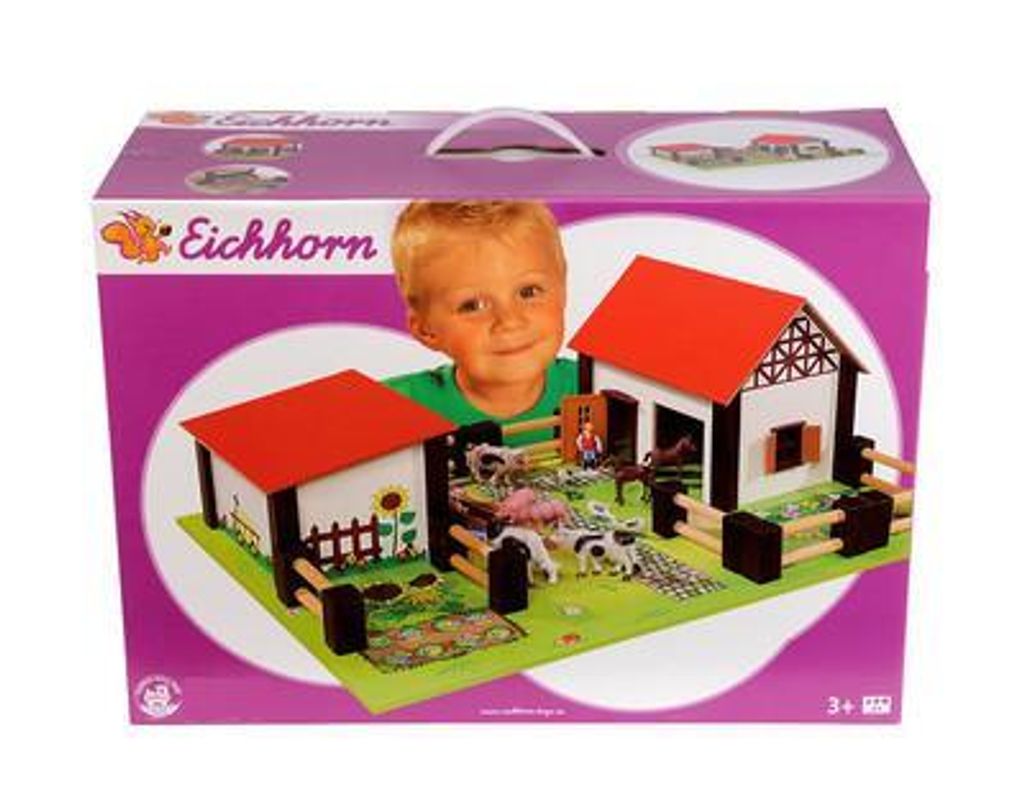 A child is looking out from behind a toy farm playset box.