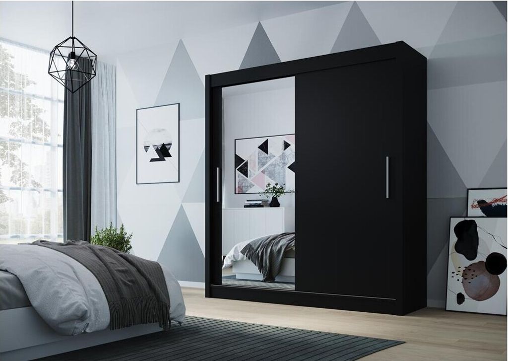 A bedroom scene featuring a large black sliding door wardrobe with a mirrored front, placed next to a bed.