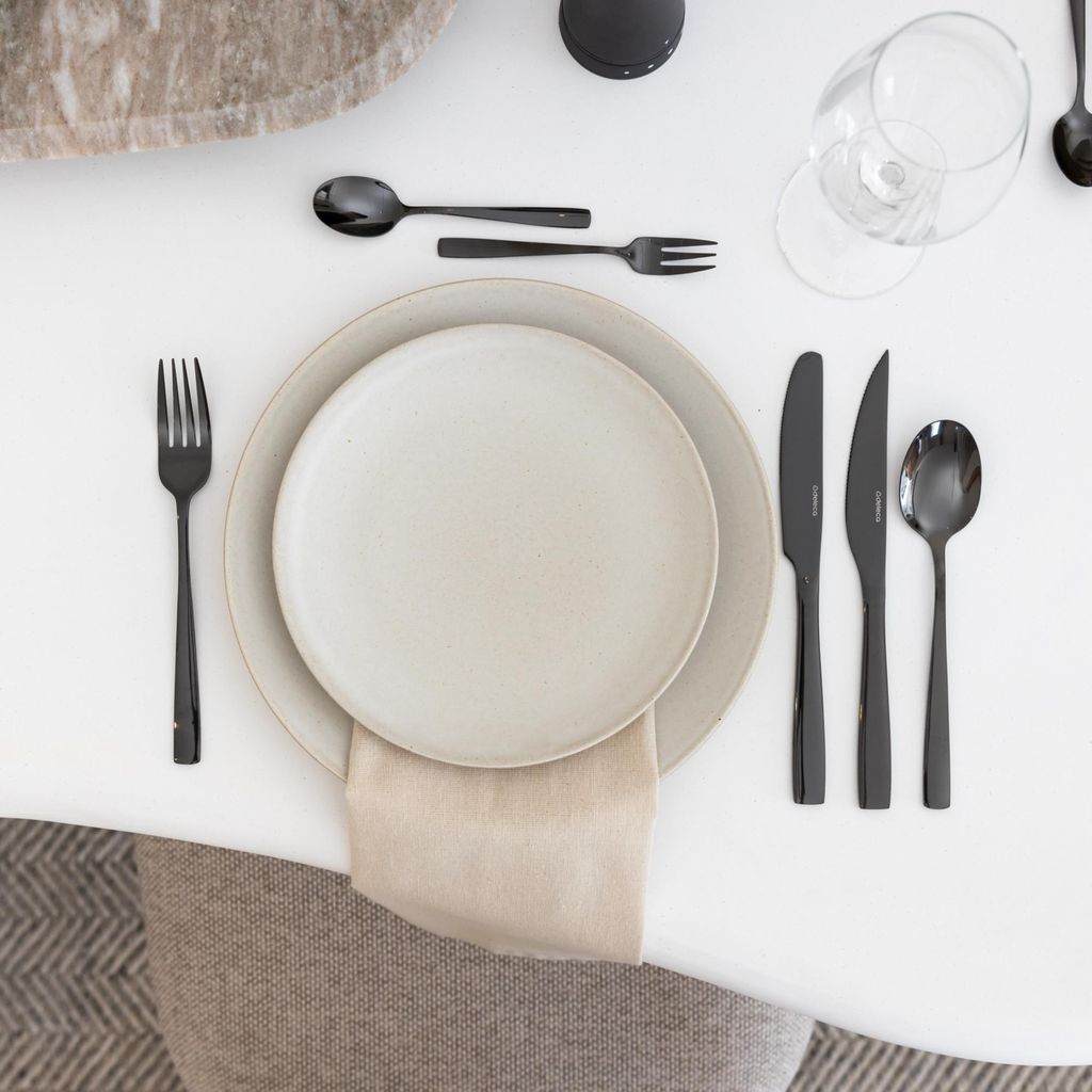 A table setting with plates, cutlery, and a napkin.