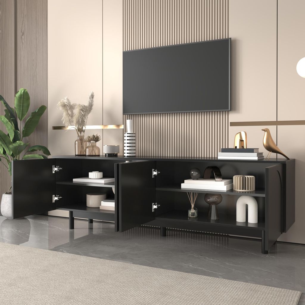 A modern living room scene featuring a black TV stand with open doors, displaying decorative items and books, with a large television mounted on the wall above it.
