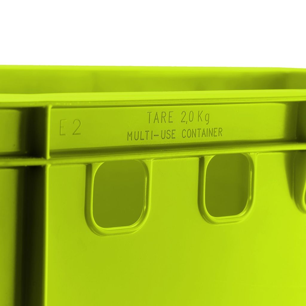A close-up view of a green plastic crate, showing embossed text and handle cutouts.