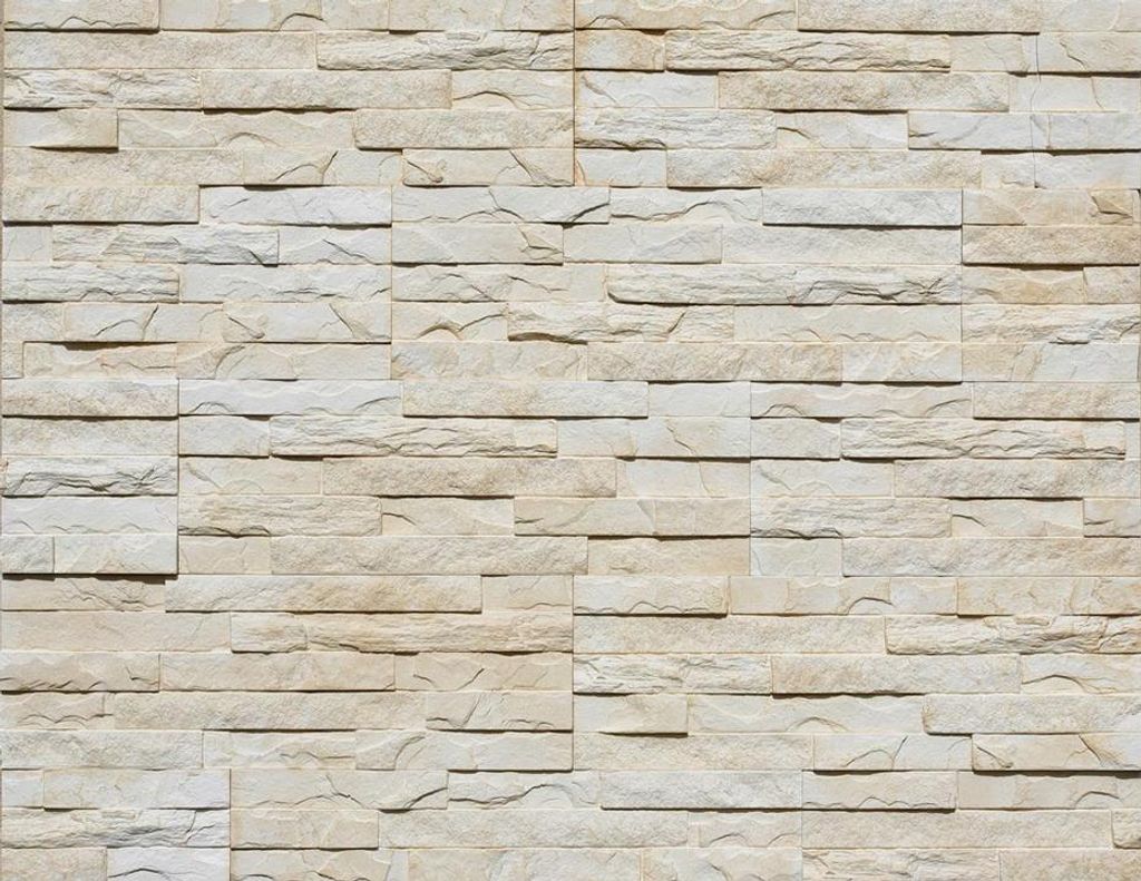 A full-frame shot of a wall covered in stacked stone veneer tiles.