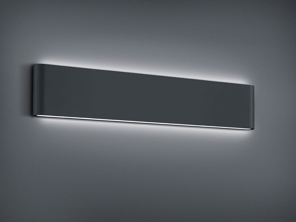 A dark gray, rectangular wall light fixture with subtle white LED lighting along the top and bottom edges, mounted on a gray wall.