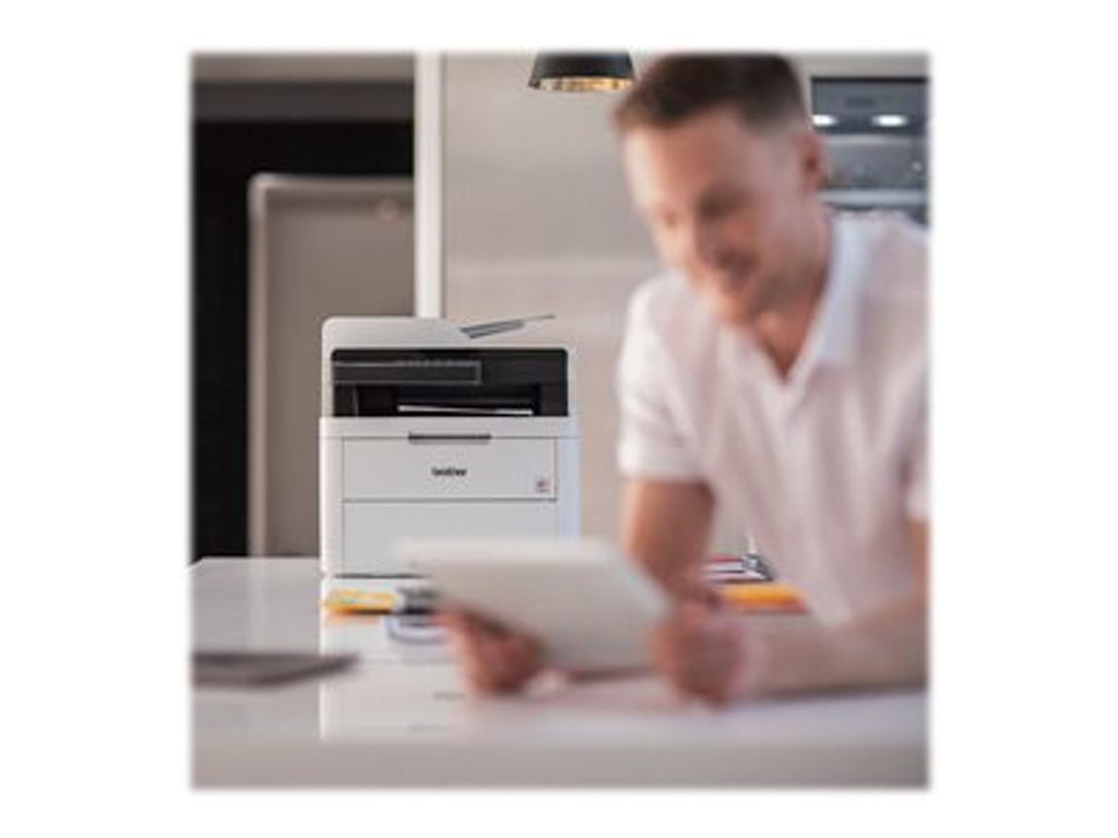 A man is using a tablet in front of a Brother printer.