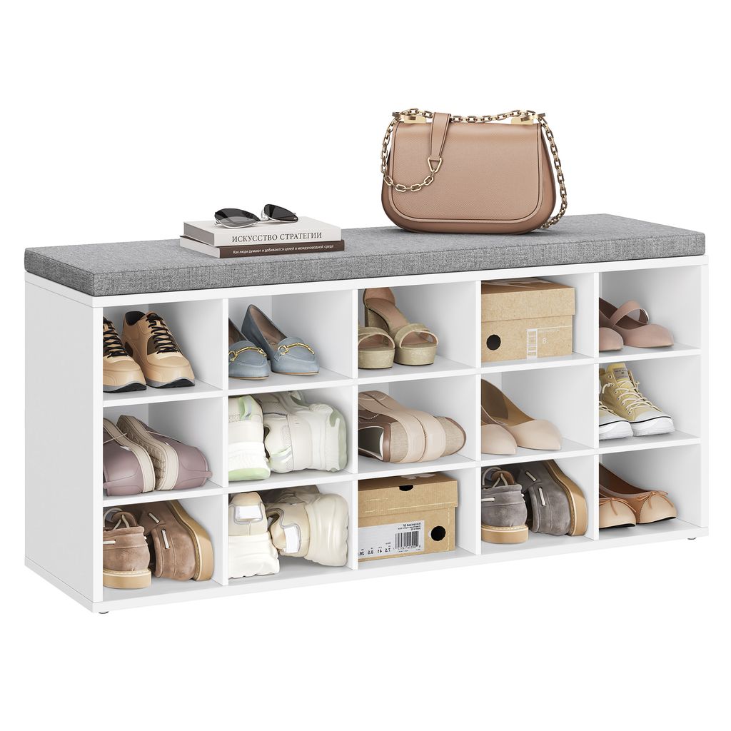 A white shoe rack with a gray cushion on top, filled with various shoes and two boxes.